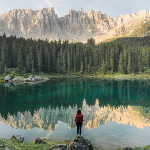 woman looking over body of water in the mountains